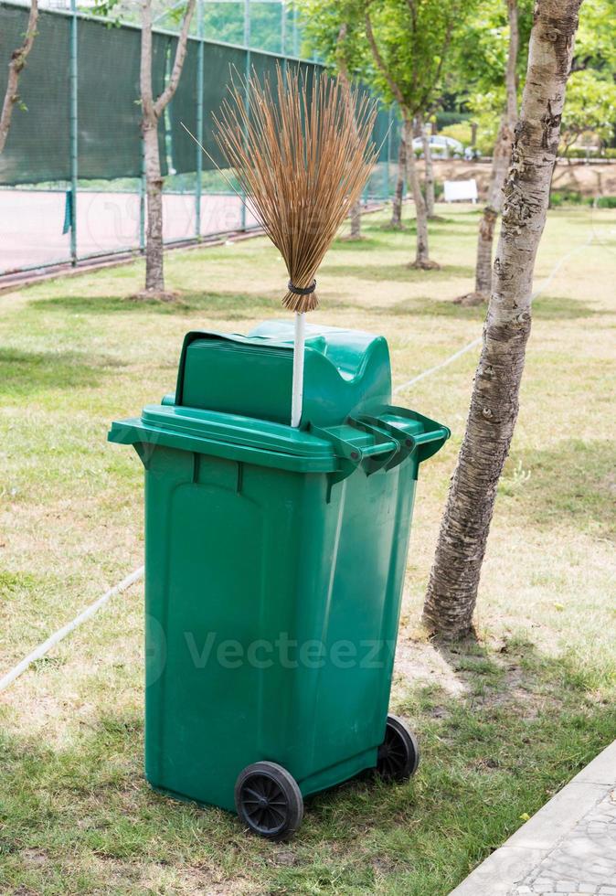 Green trash can and coconut stick broom 9391309 Stock Photo at Vecteezy