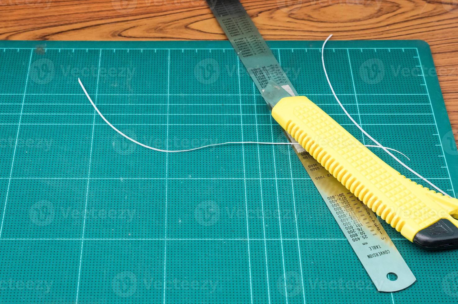 Yellow cutter and metal ruler. photo