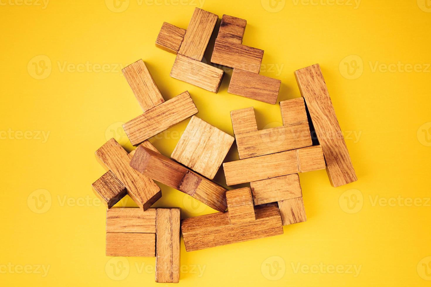 Different shapes wooden blocks on yellow background photo