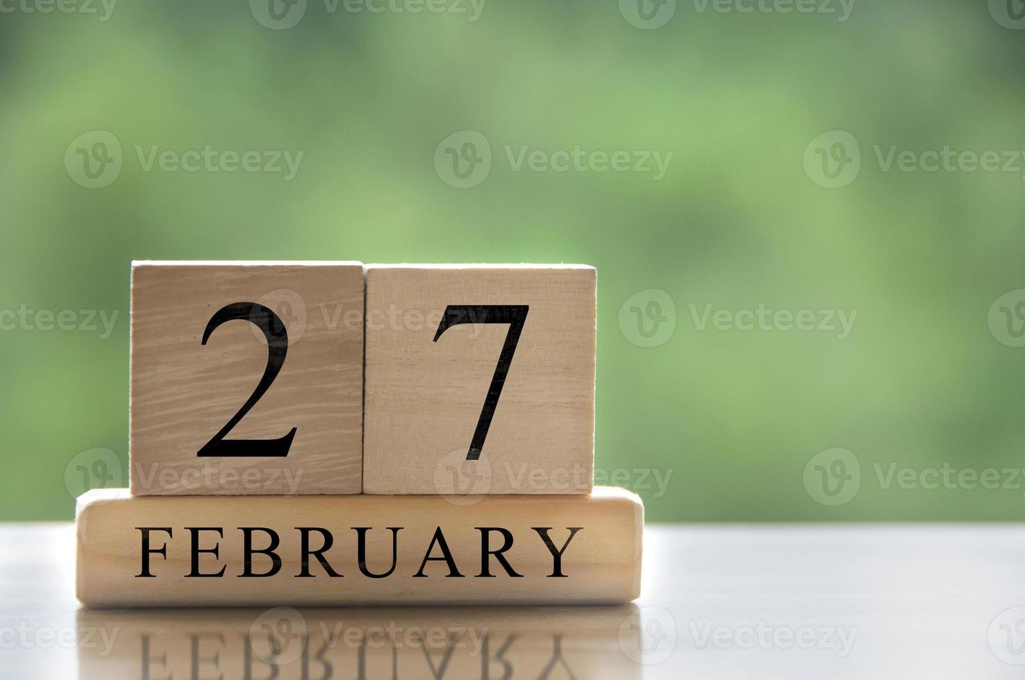 27 de febrero texto de fecha de calendario en bloques de madera con espacio personalizable para texto o ideas. copie el espacio foto