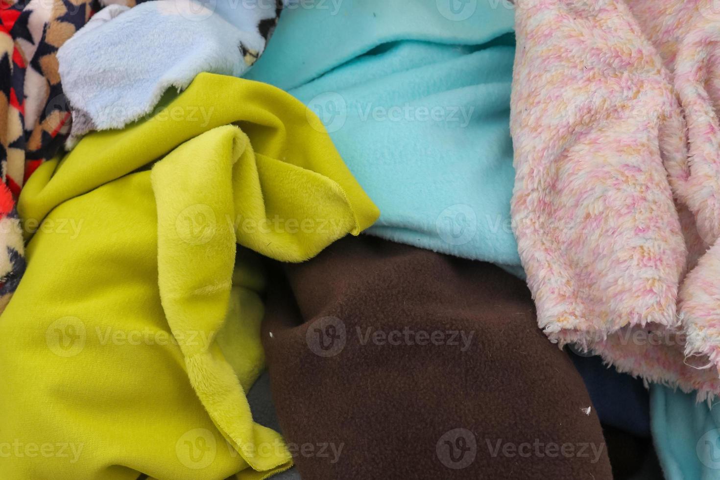 Detailed close up view on samples of cloth and fabrics in different colors found at a fabrics market photo