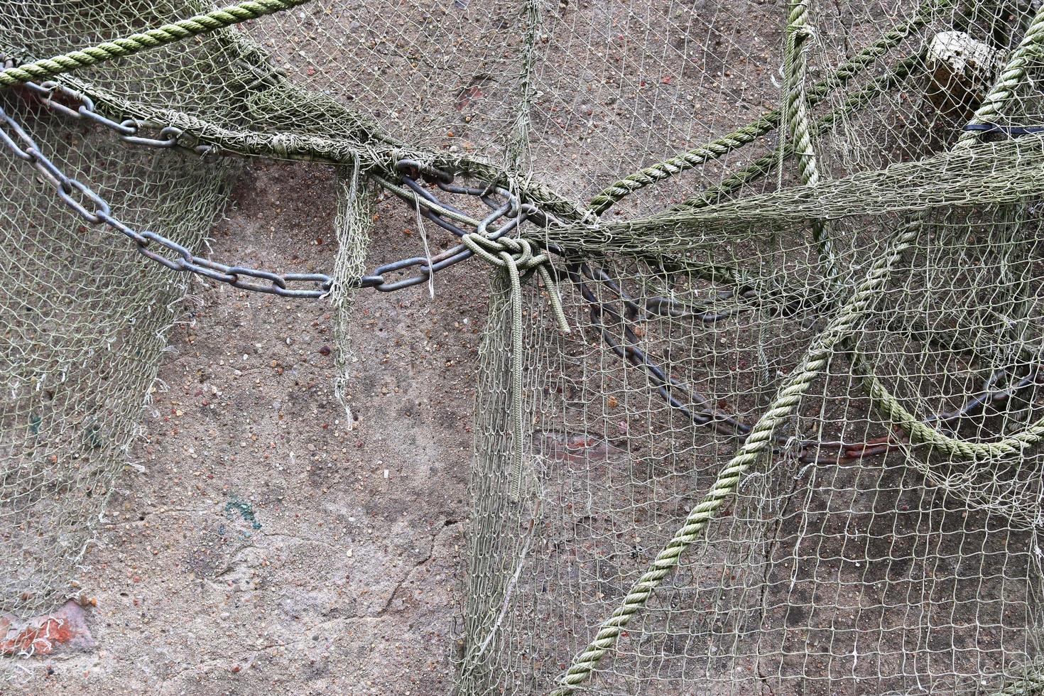 Close up view on a fishing net decoration on an old weathered wall. photo