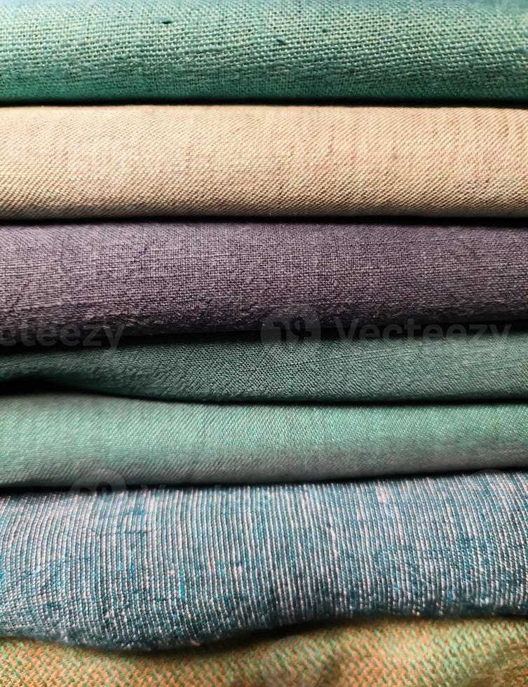 Detailed close up view on samples of cloth and fabrics in different colors found at a fabrics market photo