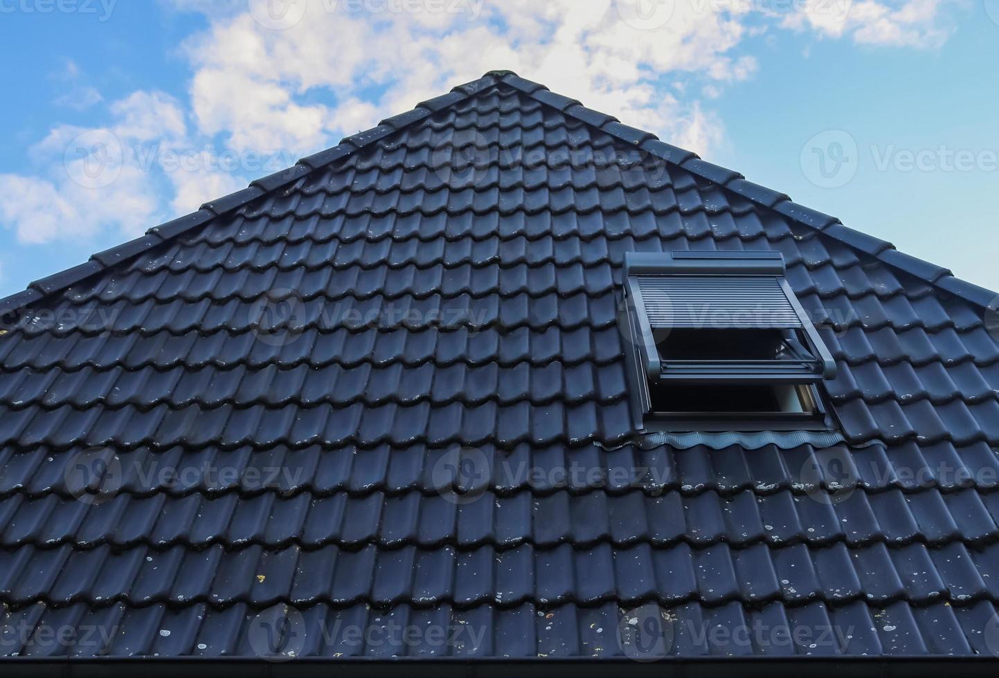 Open roof window in velux style with black roof tiles. photo