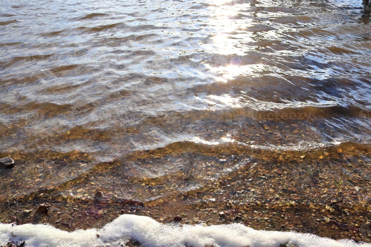 vista detallada de las superficies de agua con ondas y ondas y la luz del sol reflejada en la superficie foto