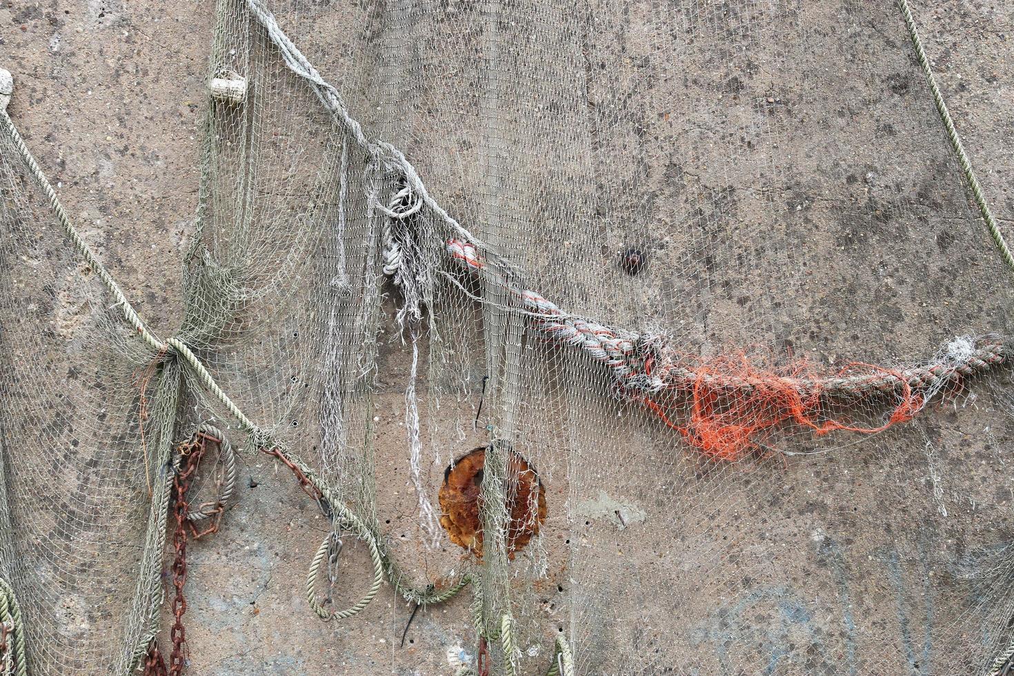 Close up view on a fishing net decoration on an old weathered wall. photo