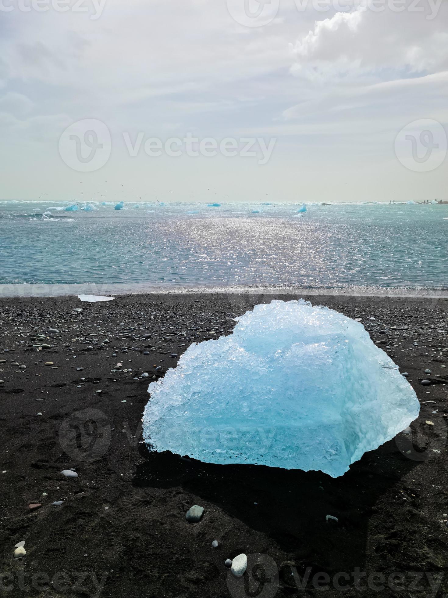 Diamond Beach in Iceland with blue icebergs melting on black sand and