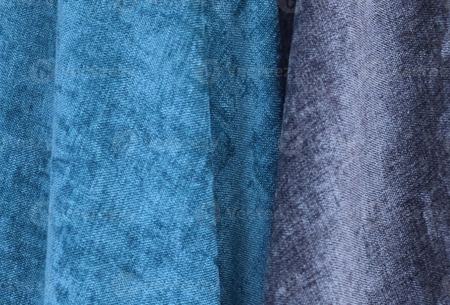 Detailed close up view on samples of cloth and fabrics in different colors found at a fabrics market photo