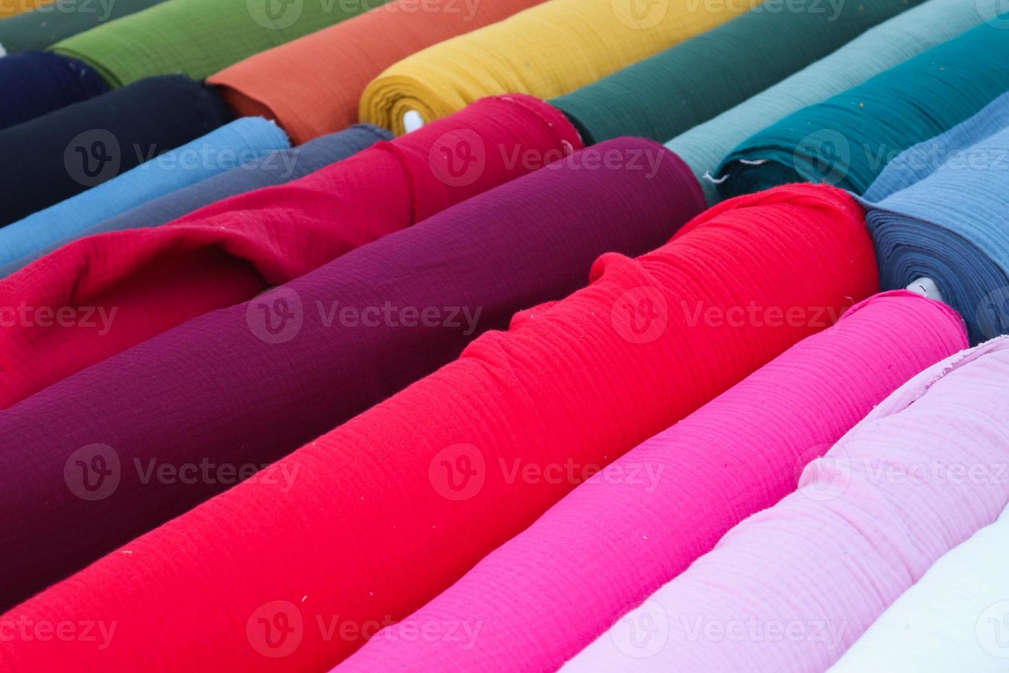Close up view on samples of cloth and fabrics in different colors found at a fabrics market photo