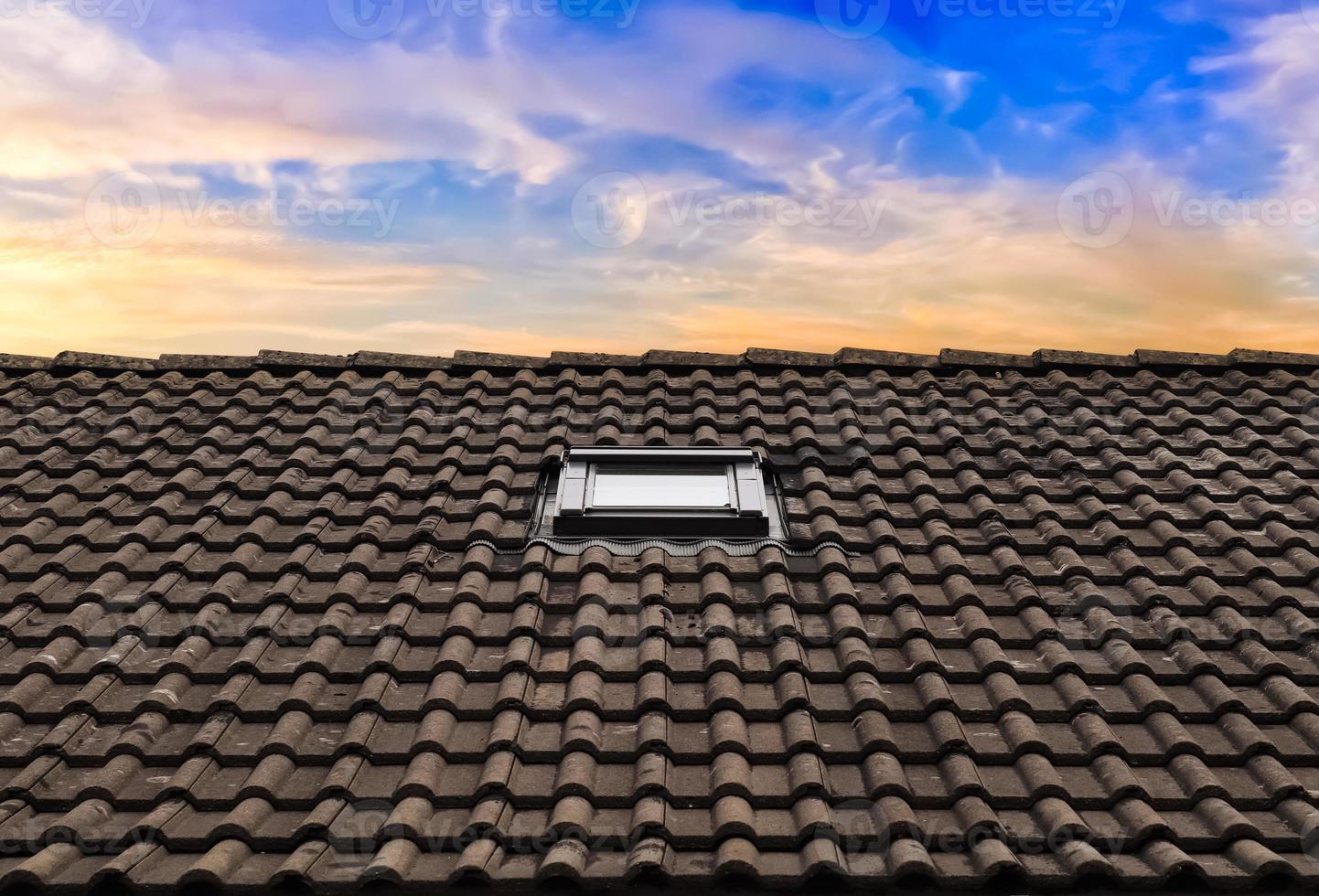 Roof window in velux style with dark roof tiles. photo