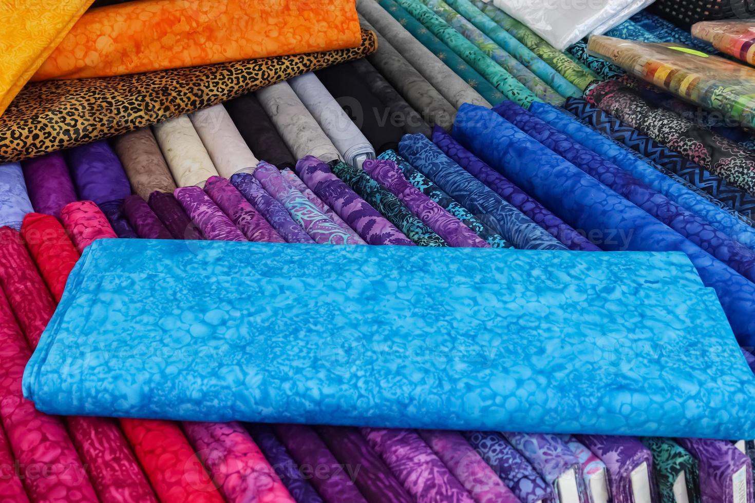 Detailed close up view on samples of cloth and fabrics in different colors found at a fabrics market photo