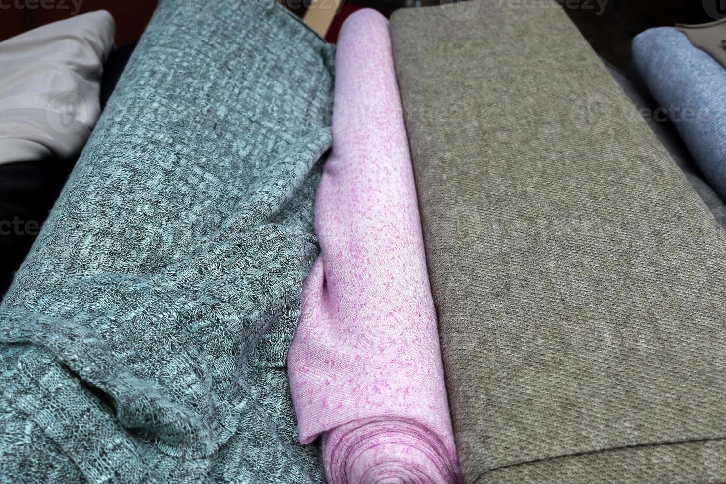 Detailed close up view on samples of cloth and fabrics in different colors found at a fabrics market photo
