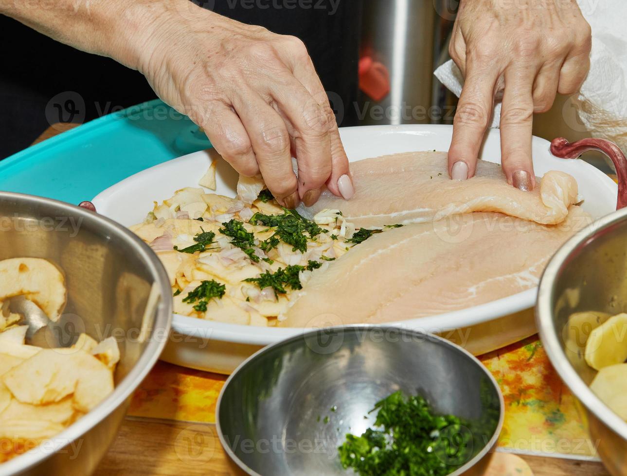 el chef prepara el filete de pescado para preparar pescado gratinado con patatas y manzanas. exquisita cocina francesa foto