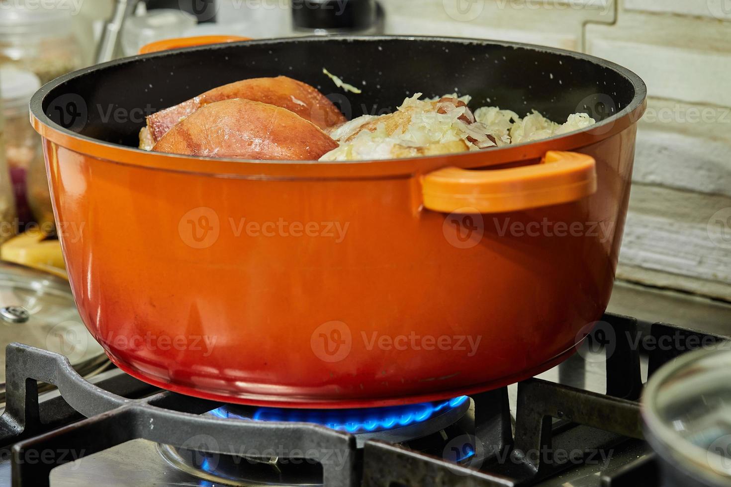 Alsatian sauerkraut is cooked in saucepan over low heat on gas stove photo