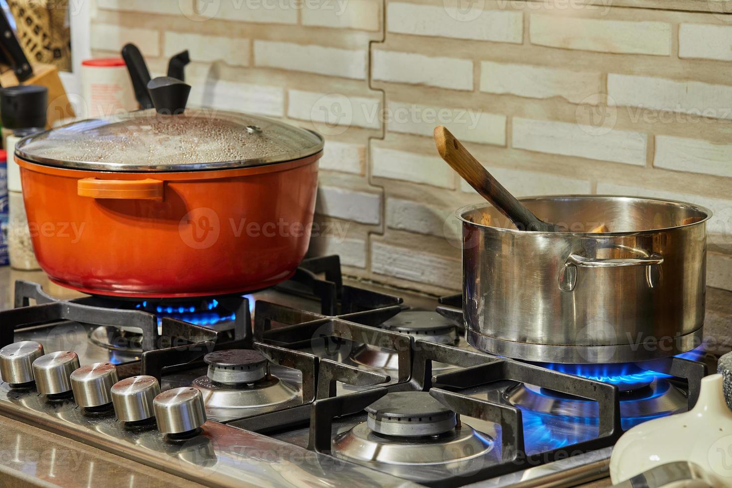 Preparing food in frying pan and casseroles on the gas stove in the kitchen. Home cooking concept photo