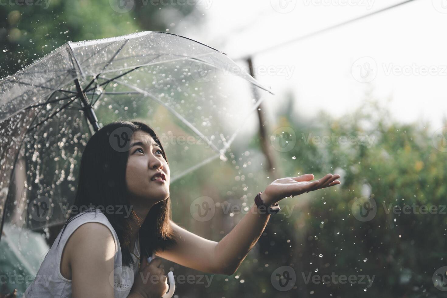 Asian woman spreads an umbrella and reaches out to play in the ...