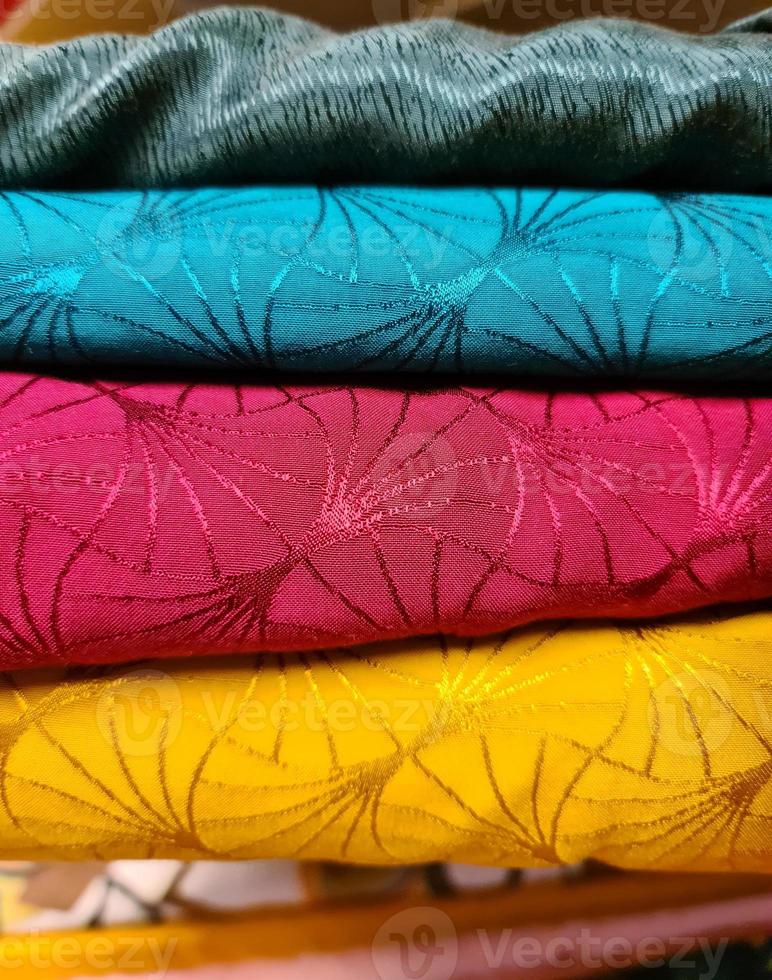 Detailed close up view on samples of cloth and fabrics in different colors found at a fabrics market photo