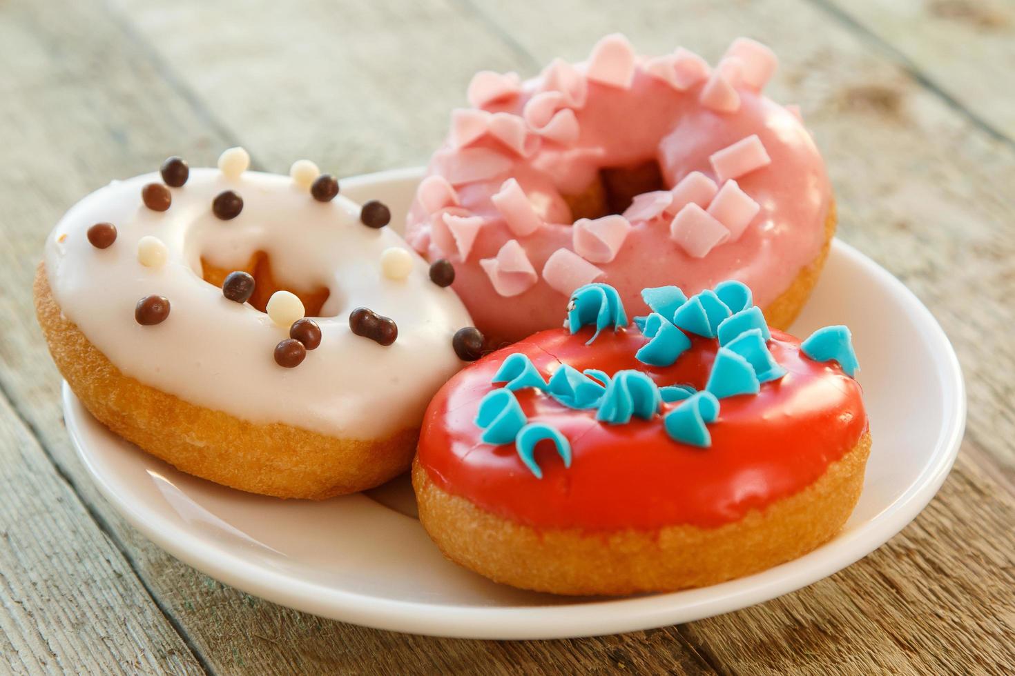 Colorful donuts on wooden table photo