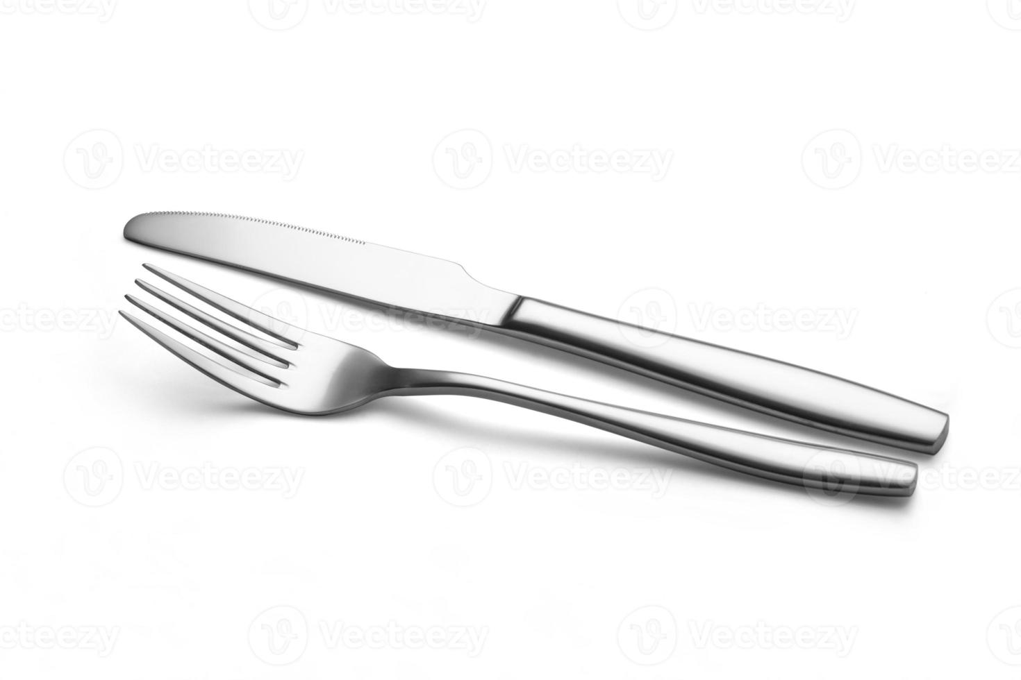 The metal shiny fork and knife on a white background. photo