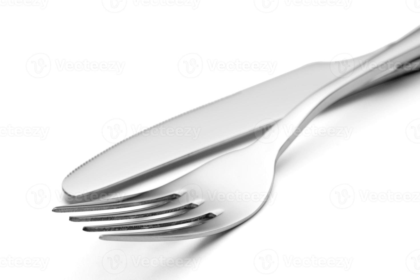 The metal shiny fork and knife on a white background. photo