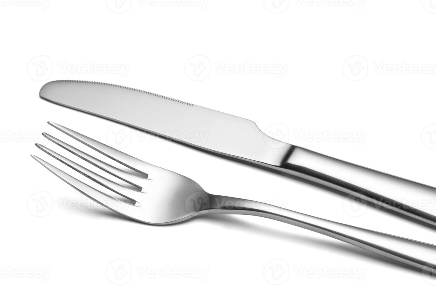 The metal shiny fork and knife on a white background. photo