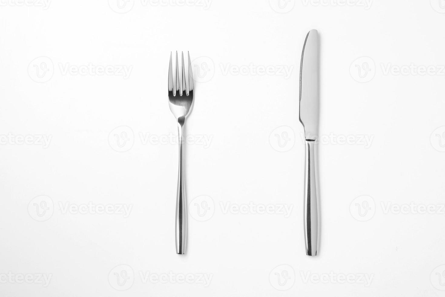 el tenedor y el cuchillo de metal brillante sobre un fondo blanco. foto