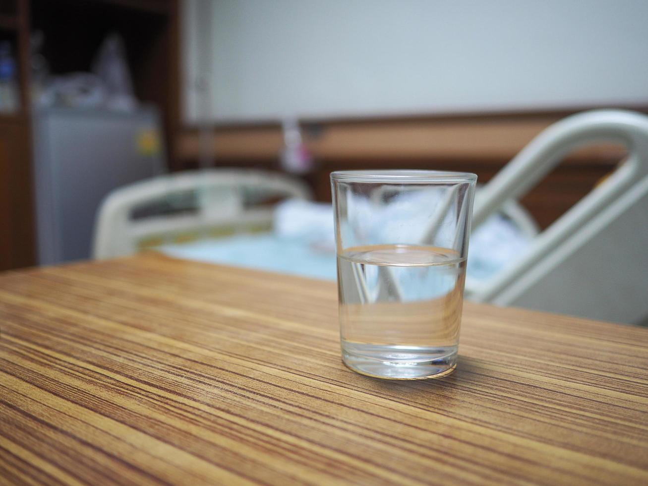 un vaso de agua sobre una mesa en una habitación del hospital foto