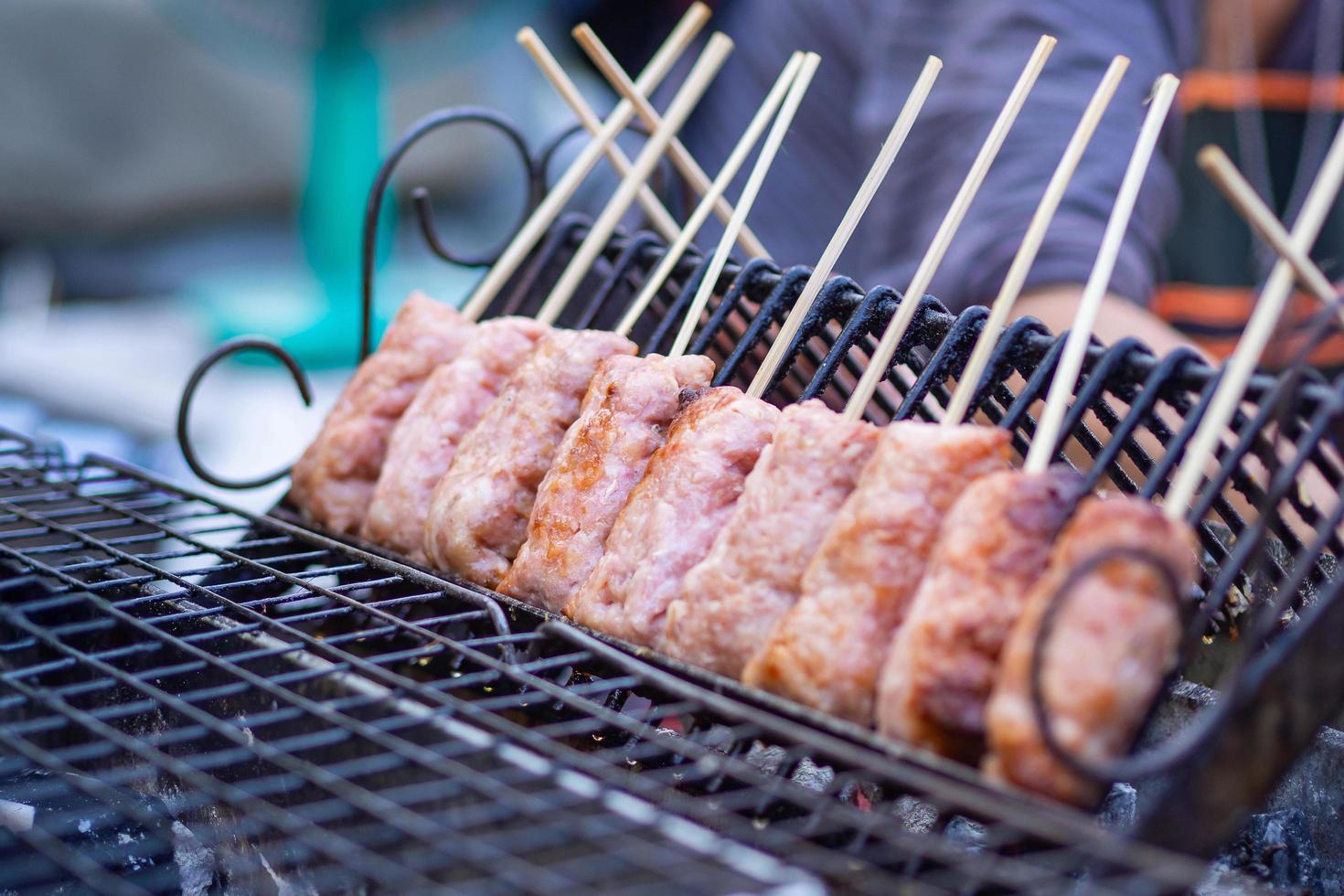 Close-up of Thai sausages grilling on stove for sale in the fresh market photo