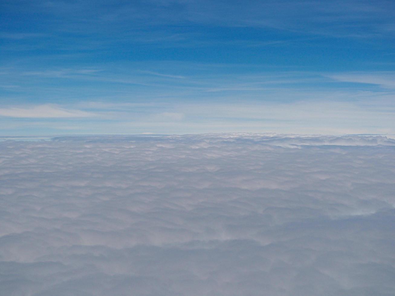 Aerial view of cloudscape seen through airplane window photo