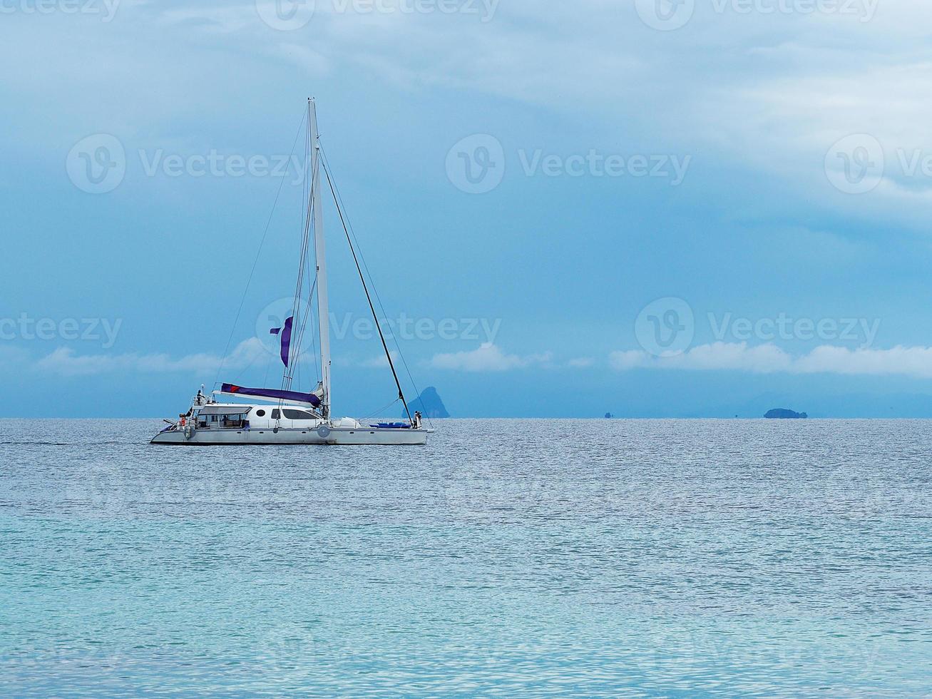 Seascape beautiful of bright blue sea surface with floating white yacht photo