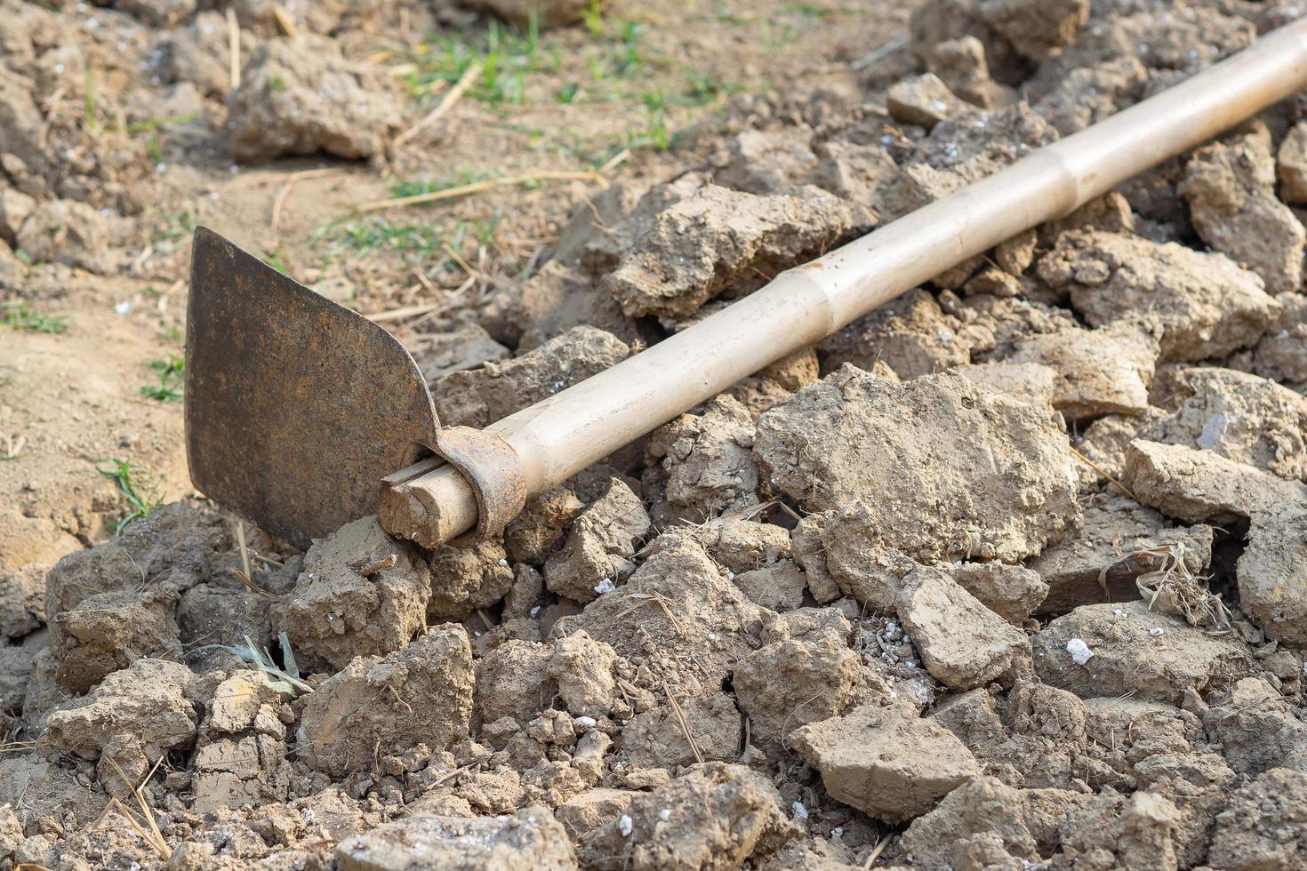 primer plano de suelo seco y azada, prepárese para la jardinería foto