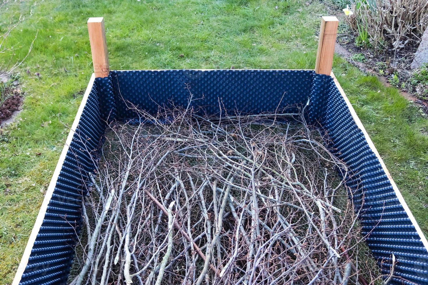 Raised herbal bed during construction with some branches in it photo