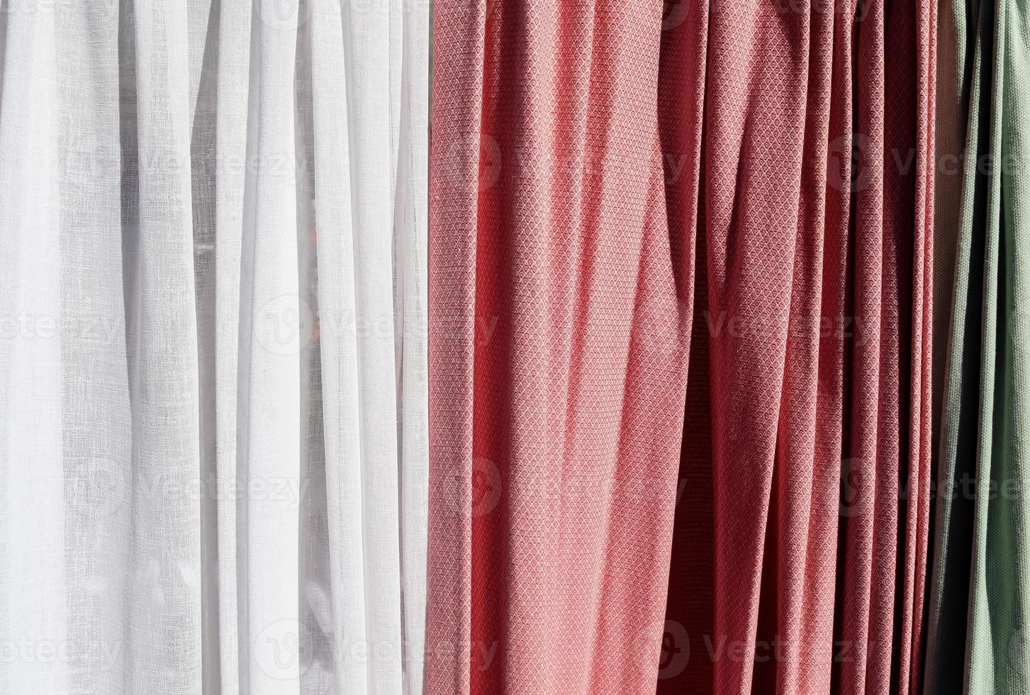 Detailed close up view on samples of cloth and fabrics in different colors found at a fabrics market photo