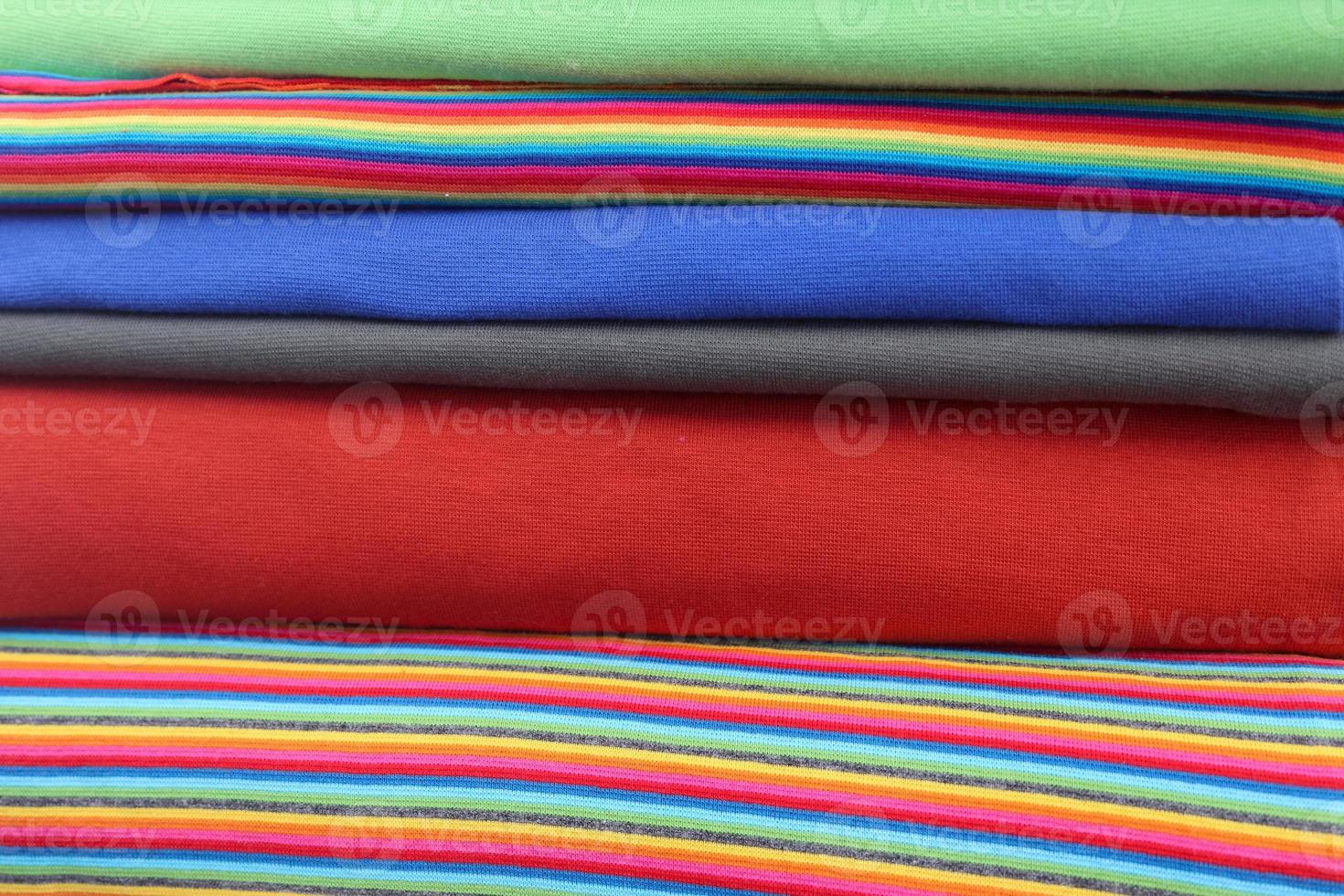 Detailed close up view on samples of cloth and fabrics in different colors found at a fabrics market photo