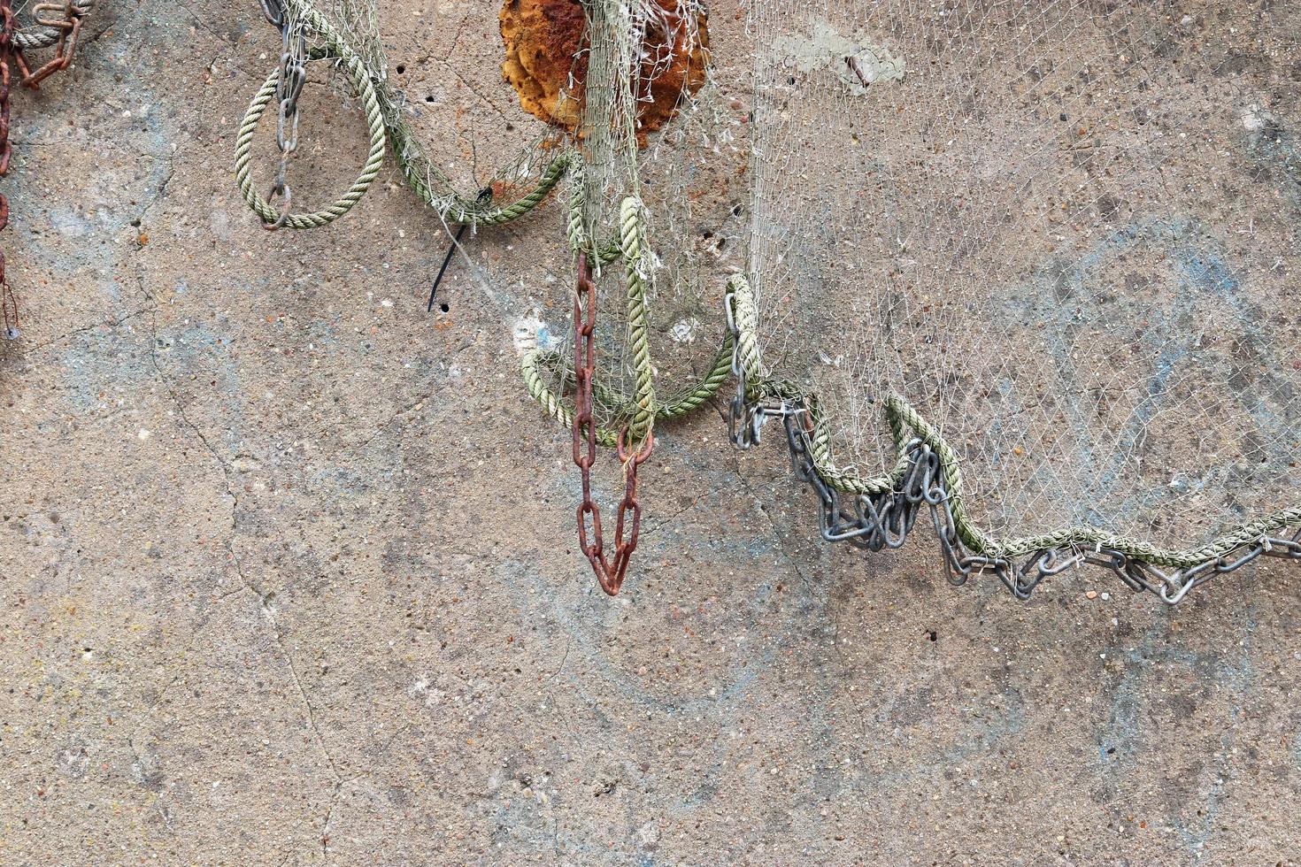 Close up view on a fishing net decoration on an old weathered wall. photo