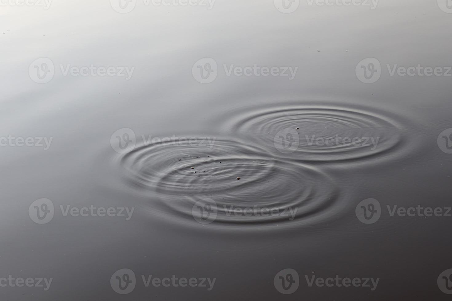 Detailed close up view on water surfaces with ripples and waves and the sunlight reflecting at the surface photo