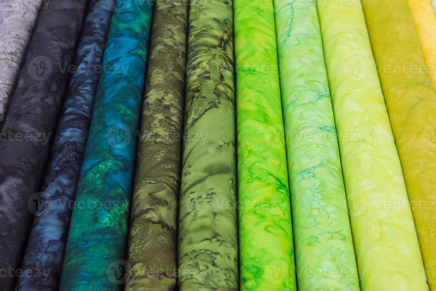 Detailed close up view on samples of cloth and fabrics in different colors found at a fabrics market photo