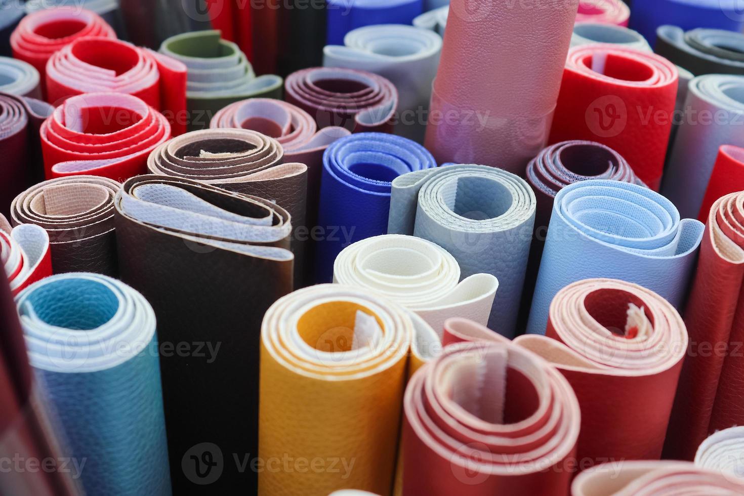 Close up view on rolled samples of cloth and fabrics in different colors found at a fabrics market.. photo