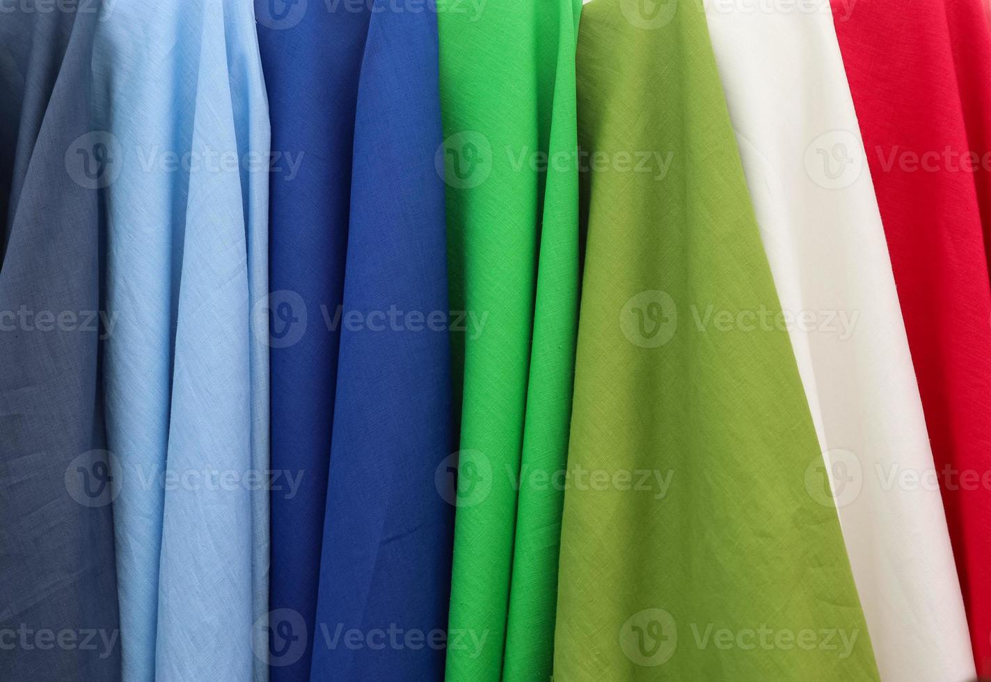 Detailed close up view on samples of cloth and fabrics in different colors found at a fabrics market photo
