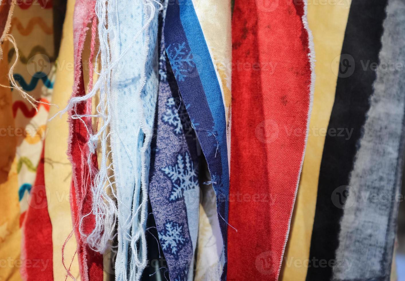 Detailed close up view on samples of cloth and fabrics in different colors found at a fabrics market photo