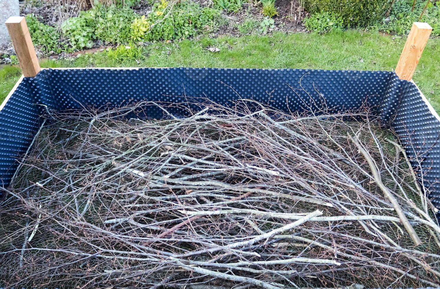 Raised herbal bed during construction with some branches in it photo