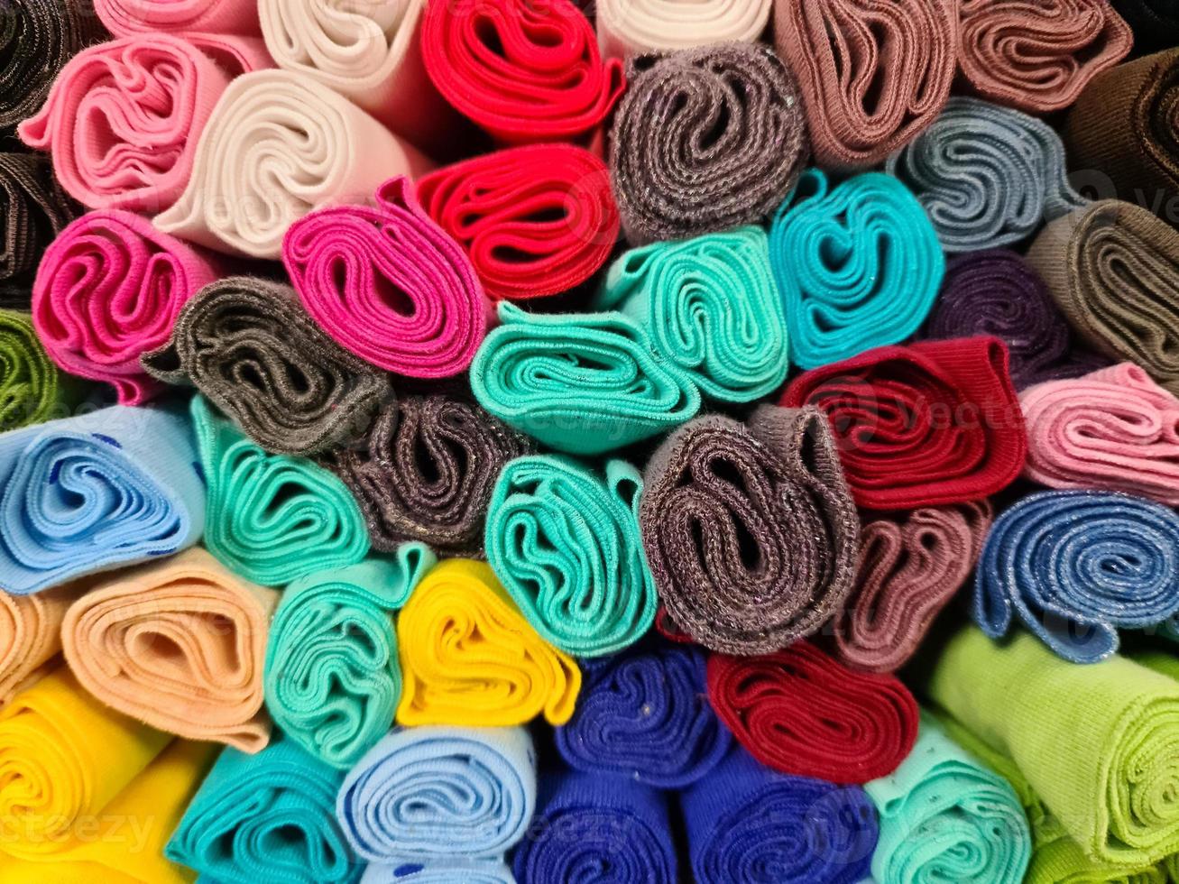 Detailed close up view on samples of cloth and fabrics in different colors found at a fabrics market photo