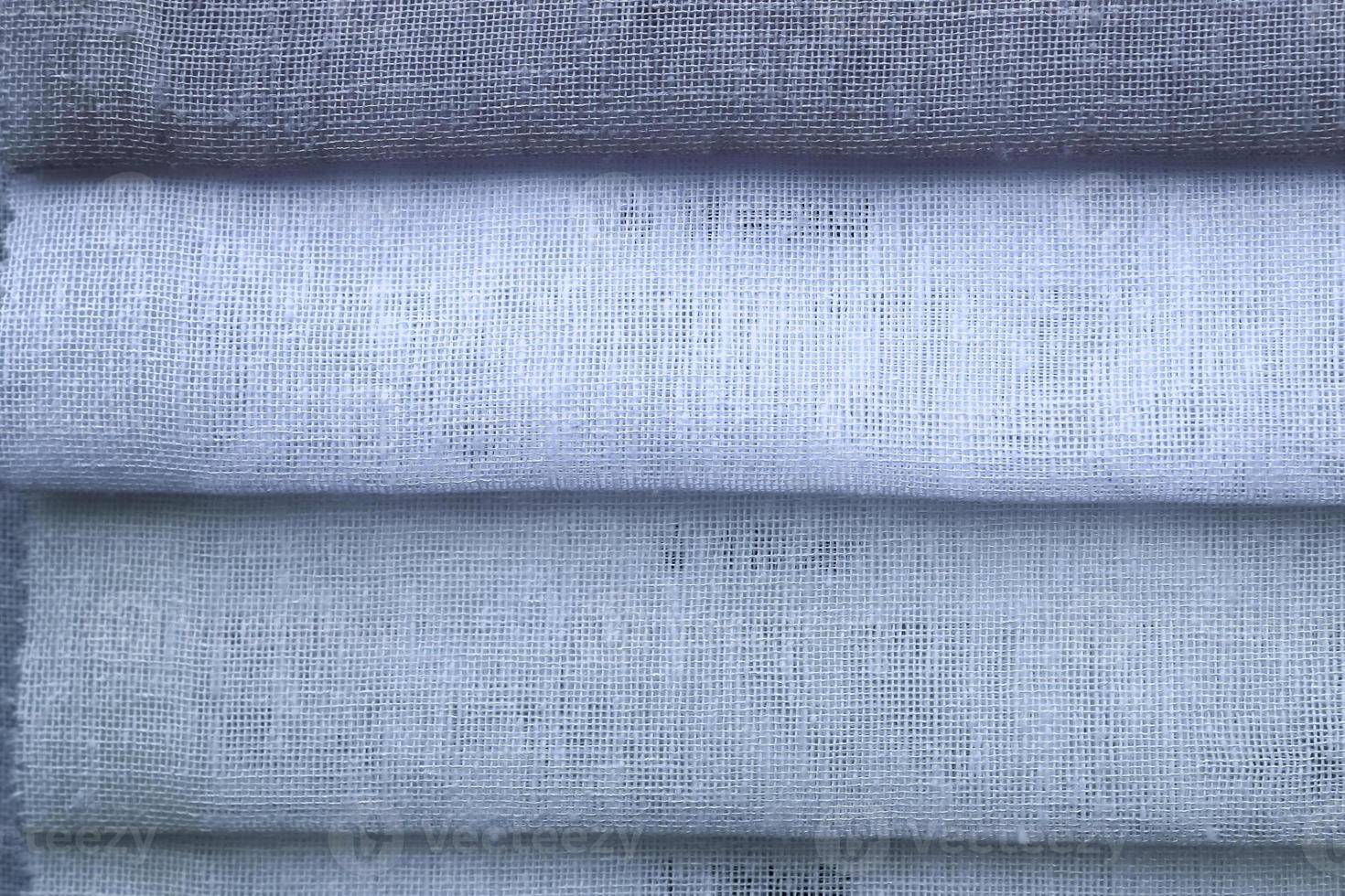 Detailed close up view on samples of cloth and fabrics in different colors found at a fabrics market photo