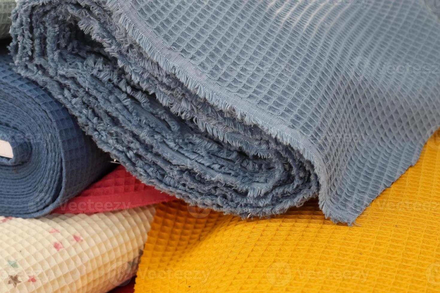Detailed close up view on samples of cloth and fabrics in different colors found at a fabrics market photo