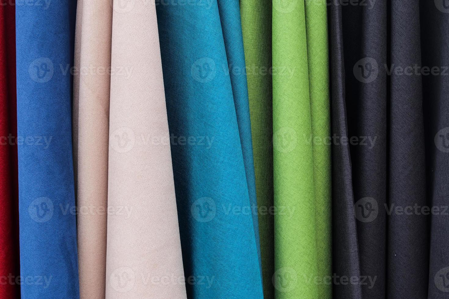 Detailed close up view on samples of cloth and fabrics in different colors found at a fabrics market photo