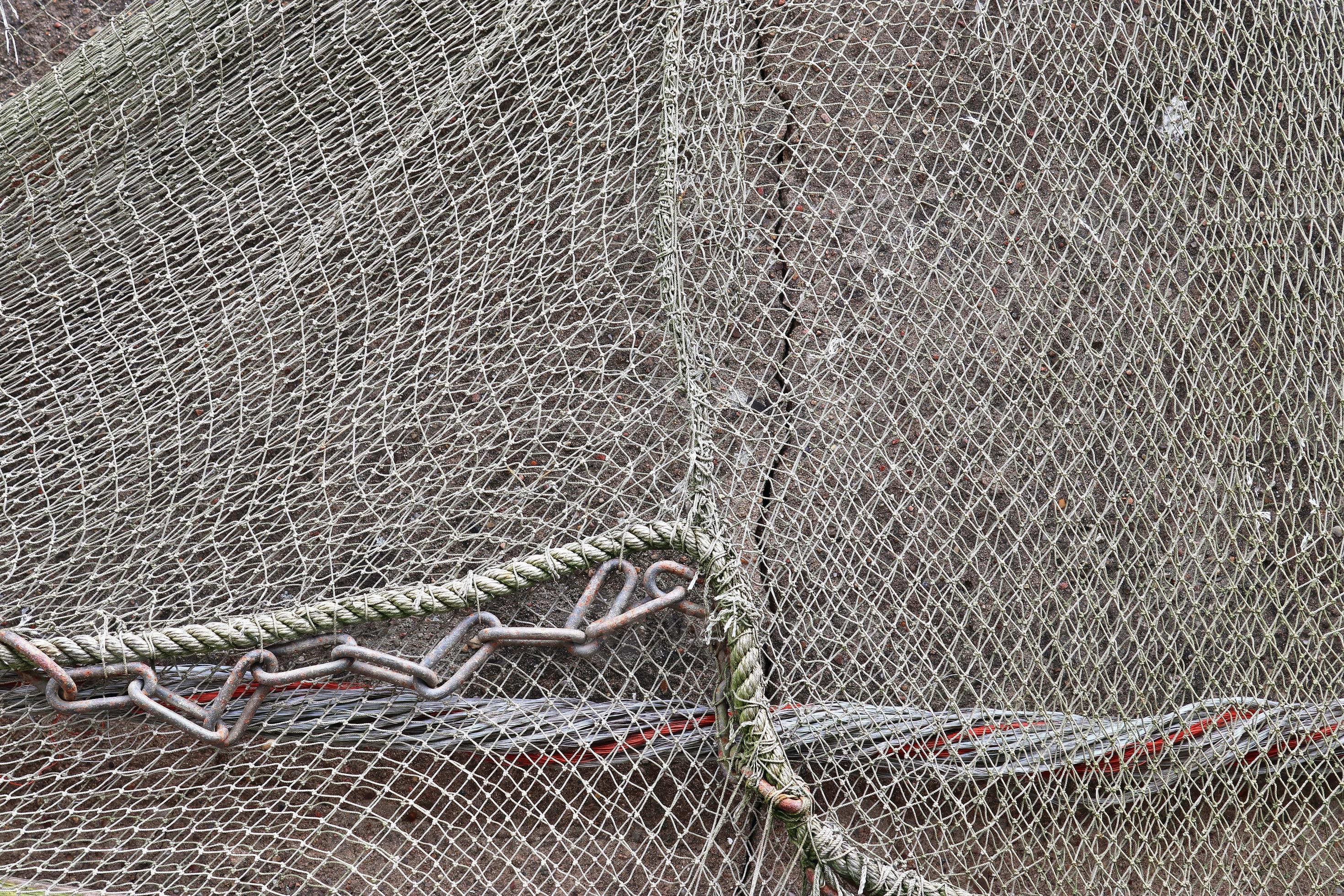 https://static.vecteezy.com/system/resources/previews/009/404/145/large_2x/close-up-view-on-a-fishing-net-decoration-on-an-old-weathered-wall-photo.jpg