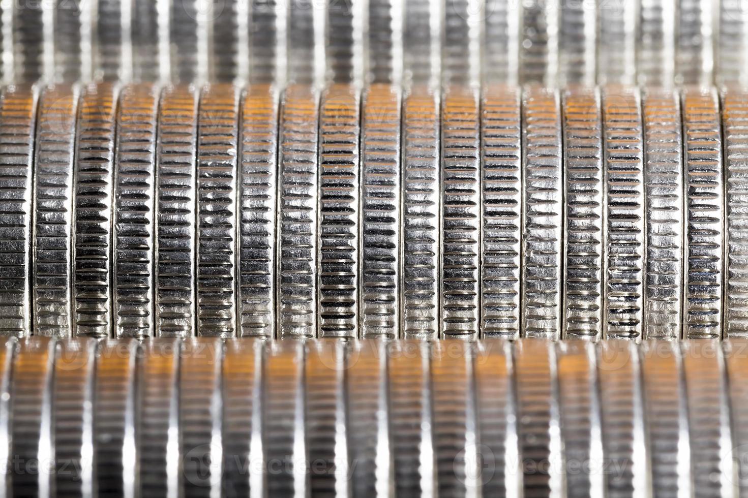many round metal coins of silver color illuminated in red photo