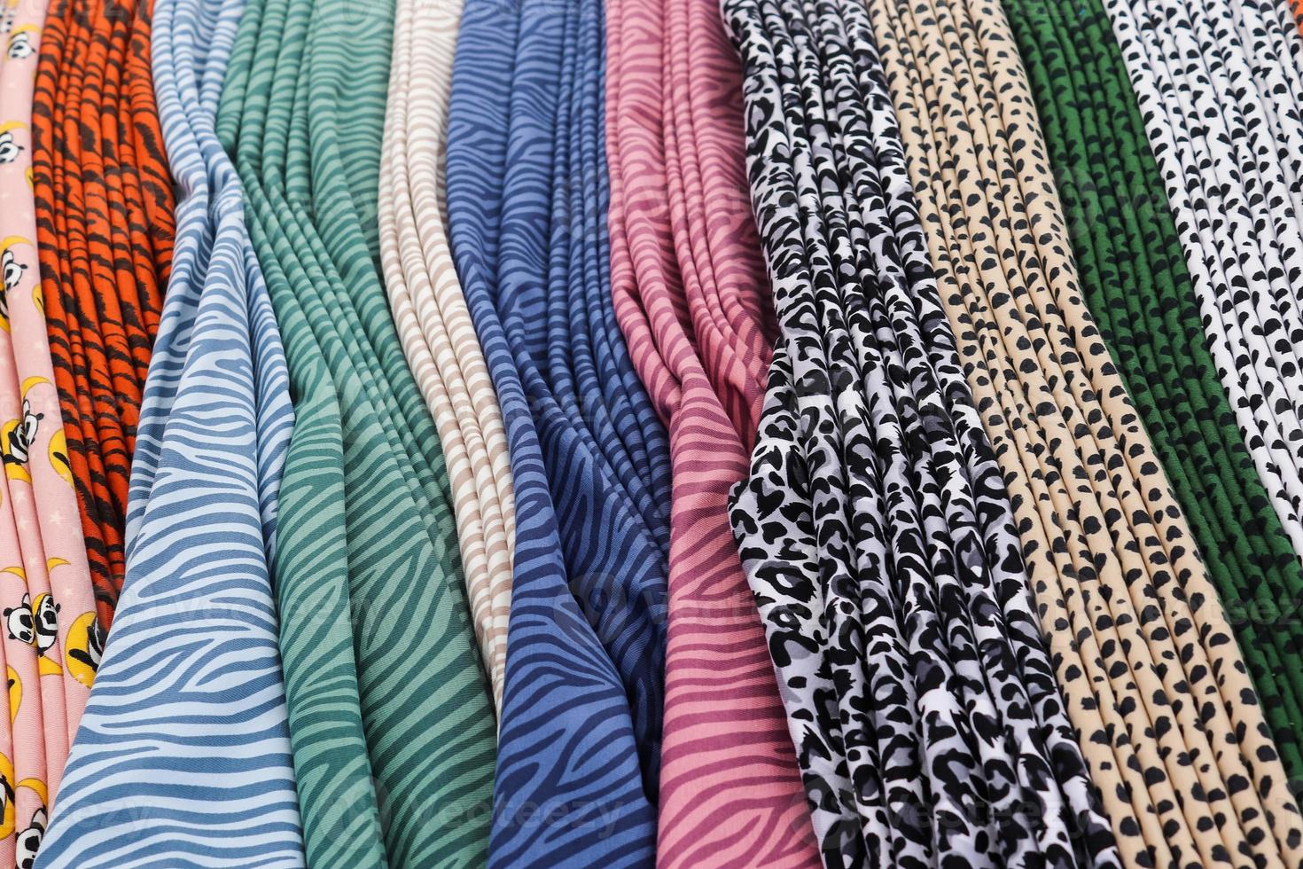 Detailed close up view on samples of cloth and fabrics in different colors found at a fabrics market photo