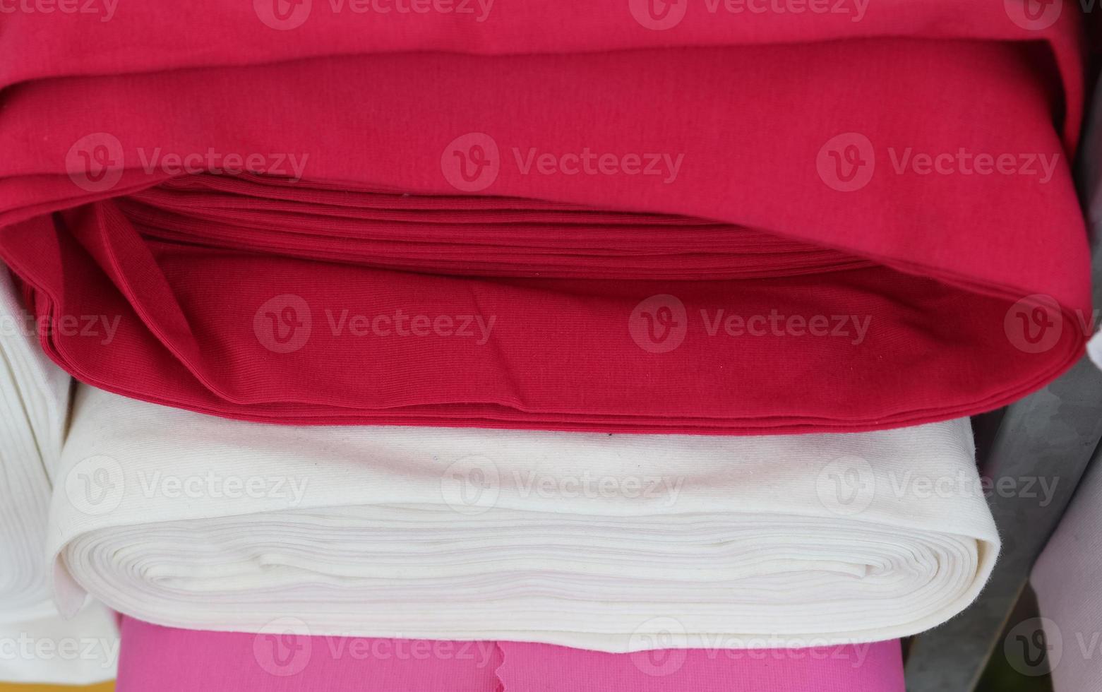 Detailed close up view on samples of cloth and fabrics in different colors found at a fabrics market photo