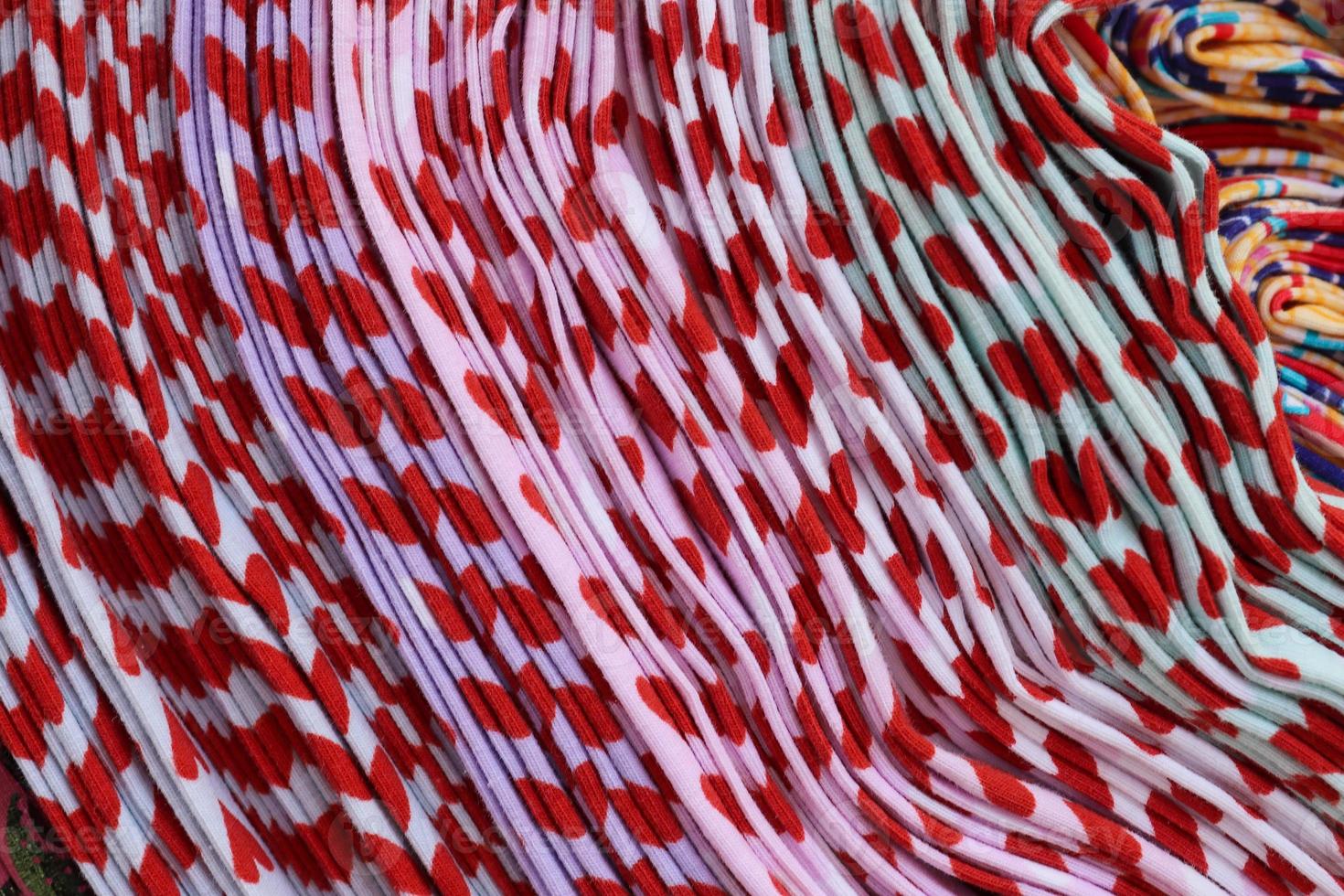 Detailed close up view on samples of cloth and fabrics in different colors found at a fabrics market photo